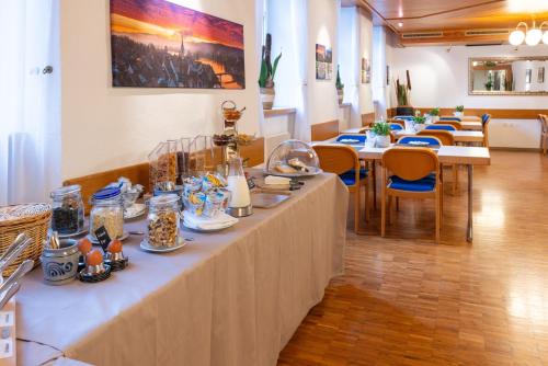una mesa larga en una habitación con mesas y sillas en Hotel Adler en Stein am Rhein