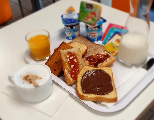 een bord ontbijtproducten met brood en melk bij Premiere Classe Brive La Gaillarde Ouest in Brive-la-Gaillarde
