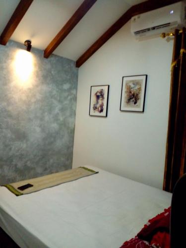 ein Zimmer mit einer Wand mit zwei Bildern darauf in der Unterkunft Fajar Home Stay Batukaras in Batukaras