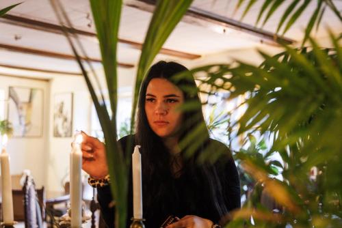 a woman is standing next to a potted plant at Karja Accommodation in Haapsalu