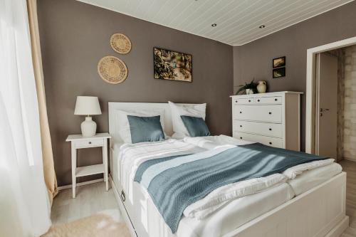 a bedroom with a white bed and a white dresser at Happy Place mit Sauna & Jacuzzi in Plettenberg