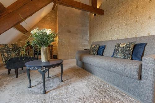 a living room with a couch and a table at Ferme de la Rançonnière - Hôtel & Restaurant in Crépon