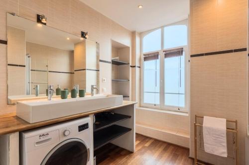 een badkamer met een wastafel en een wasmachine bij 2 bedroom apartment with terrace, near Lille in Lille