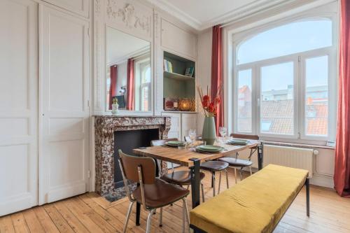 une salle à manger avec une table et des chaises et une cheminée dans l'établissement 2 bedroom apartment with terrace, near Lille, à Lille