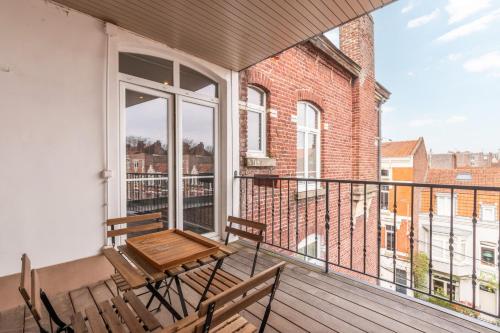 balcón con mesa y sillas de madera en 2 bedroom apartment with terrace, near Lille, en Lille