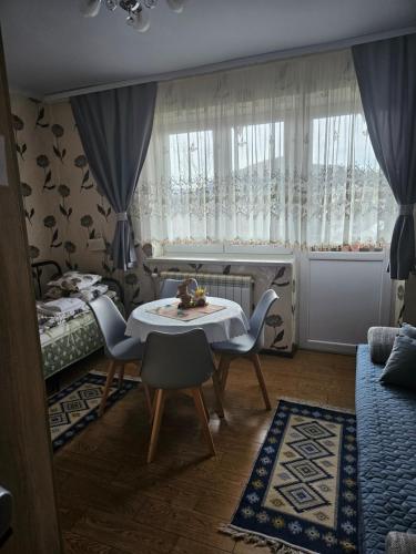 a room with a table and chairs and a bed at Noclegi MAJA in Solina