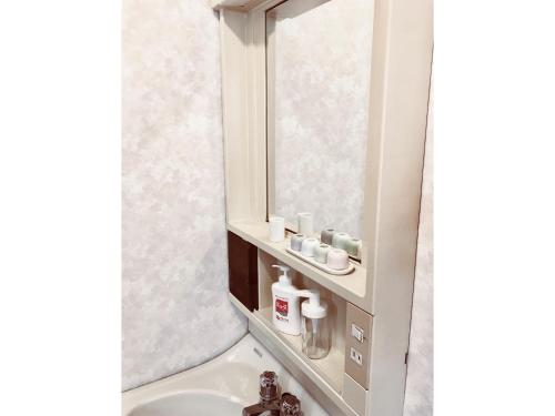 a bathroom with a sink and a mirror at Tuktuk House in Kawagoe
