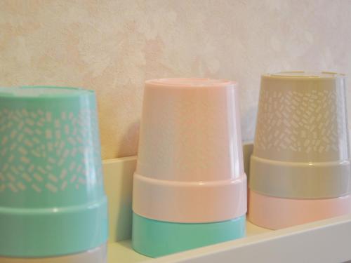 three different colored vases sitting on a shelf at Tuktuk House in Kawagoe