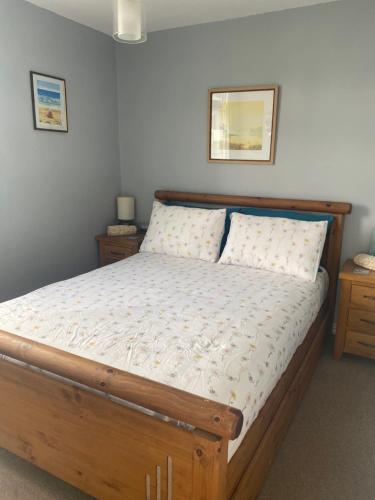 a bedroom with a wooden bed with two night stands at Delightful chalet, overlooking estuary! in Ferryside