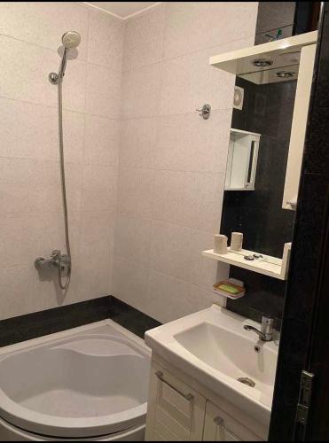 a bathroom with a sink and a toilet and a tub at Dighomi Apartment in Tbilisi City