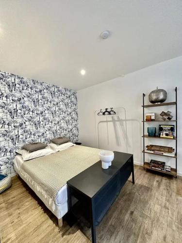 - une chambre avec un lit et une table noire dans l'établissement C. La réserve - St Rose le BLEU, à Clermont-Ferrand