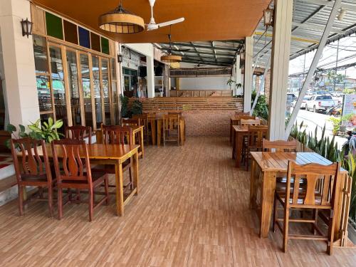 an empty restaurant with wooden tables and chairs at Srichada Hotel Khaolak - SHA Extra Plus in Khao Lak