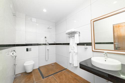 uma casa de banho branca com um lavatório e um WC em Skylar Seaview Beach Resort & Ayurveda Varkala em Varkala