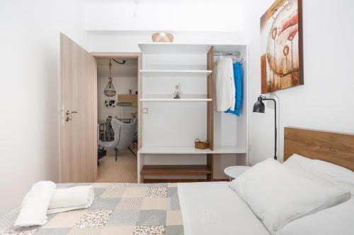 um quarto branco com uma cama e um closet em Endless View Apartment em Elliniká