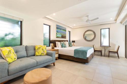 a living room with a couch and a bed at Temple Resort & Spa Port Douglas in Port Douglas