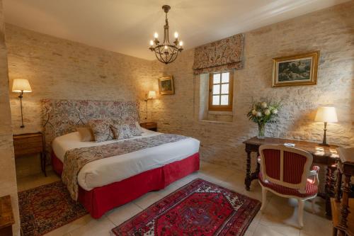 a bedroom with a bed and a desk and a chair at Ferme de la Rançonnière - Hôtel & Restaurant in Crépon
