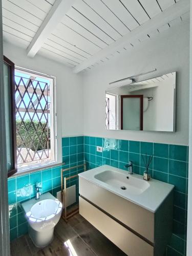 a bathroom with a sink and a toilet and a window at Italianflat - Villa Andrea Doria in Costa Rei
