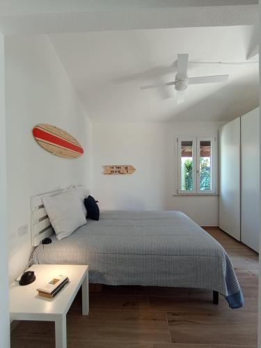 a white bedroom with a bed and a table at Italianflat - Villa Andrea Doria in Costa Rei