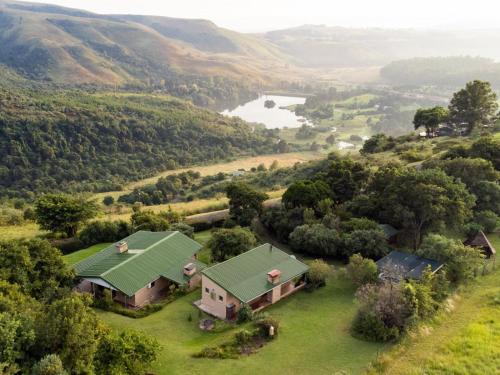 uma vista aérea de uma casa com um telhado verde em Drakensberg Creek Cottage & Drakensberg Vultures View em Champagne Valley
