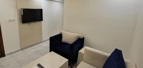 a living room with a couch and a tv at Yan Furnished Apartments in Al Khobar