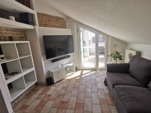 a living room with a couch and a flat screen tv at Appartamento mansardato Civitanova Marche in Civitanova Marche