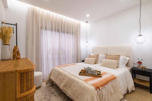 a white bedroom with a bed and a window at Beach Townhouse - Luxury, Wi-Fi, AC, 2 mins from the beach in Armação de Pêra