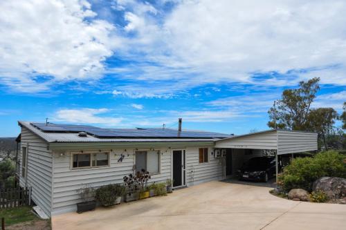 a white house with a car parked in the driveway at Eagle's Nest in Stanthorpe