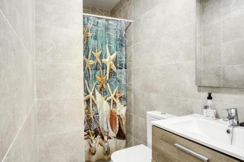 a bathroom with a shower curtain with starfish on it at El Desembarco in Villajoyosa