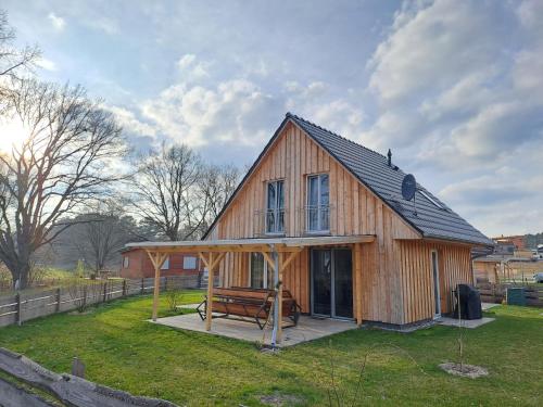 una gran casa de madera con un banco en el patio en Haus am Seeufer, en Rheinsberg