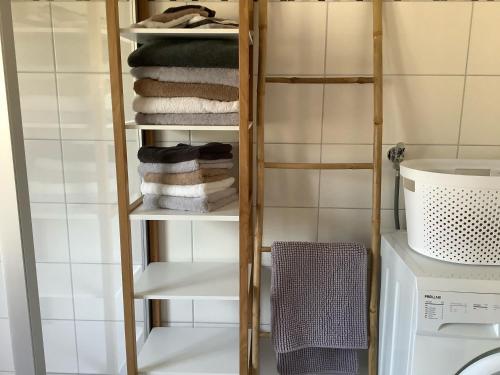 a laundry room with a rack of towels and a washing machine at Le chouette gîte in Sélestat