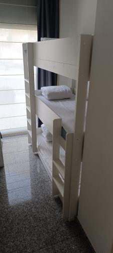 a white bunk bed in a room with a window at Appartement "Zeezicht 002" in Ostend