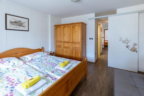 Schlafzimmer mit einem Bett und einem Holzschrank in der Unterkunft Apartma pri Andreju in Bohinj