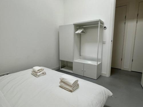 a white room with a bed with towels on it at Stylish 2 Bedroom Serviced Apartment in Rotterdam in Rotterdam