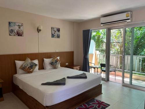 um quarto com uma cama grande e uma varanda em Srichada Hotel Khaolak - SHA Extra Plus em Khao Lak
