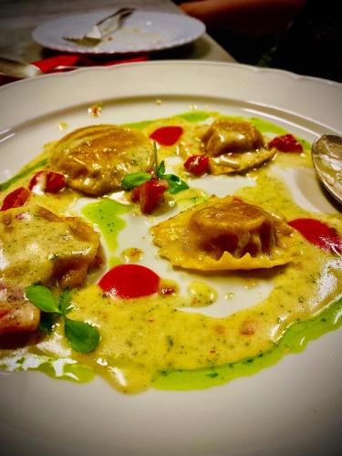 a white plate of food with eggs and sauce at LaChiusa Tuscany in Montefollonico