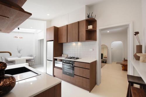 a kitchen with wooden cabinets and a stove top oven at Boutique stylish 3 Bedroom family home in Melbourne with Parking in Melbourne