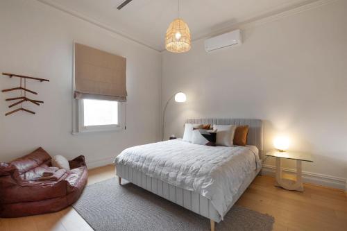a bedroom with a bed and a couch and a chair at Boutique stylish 3 Bedroom family home in Melbourne with Parking in Melbourne
