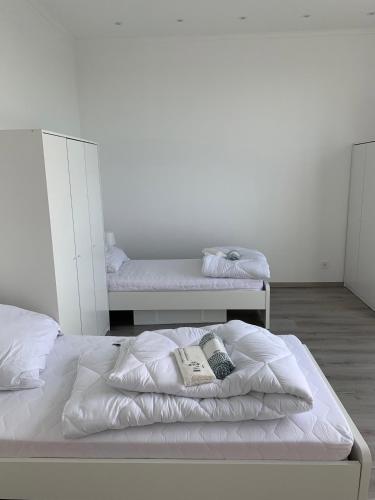 a white bedroom with two beds and a mirror at 6 Personen / WIFI / Castrop-Rauxel in Castrop-Rauxel