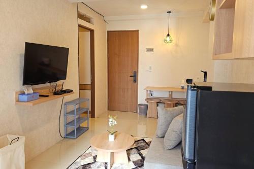 - un salon avec une télévision et une table dans l'établissement 2 BR The Oak Tower Apartment 9th Floor, à Jakarta