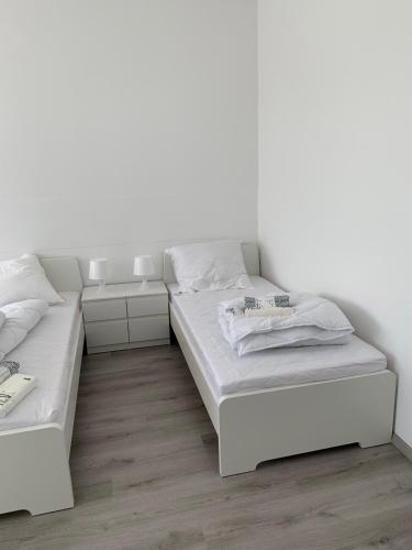 two beds in a room with white walls and wooden floors at 6 Personen / WIFI / Castrop-Rauxel in Castrop-Rauxel