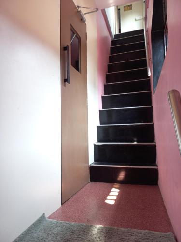 a staircase in a building with pink walls at New Assar International dormitory in Mumbai