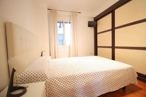 sypialnia z łóżkiem z czarno-białą narzutą w obiekcie Triana Luxury Numancia w Sewilli