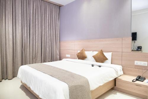 バンガロールにあるHypons Hotelのベッドルーム1室(大型ベッド1台付)