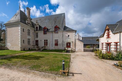 a large white house with a gray roof at Les Cahiers de Vacances in Amboise