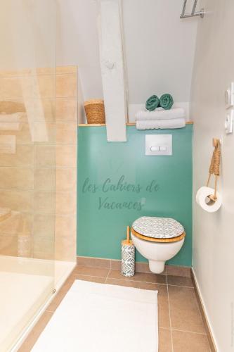a bathroom with a toilet and a sign that says las colaciones at Les Cahiers de Vacances in Amboise