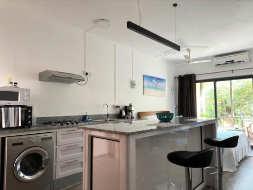 a kitchen with a sink and a washing machine at Residence Le Point Choisy in Pointe aux Cannoniers