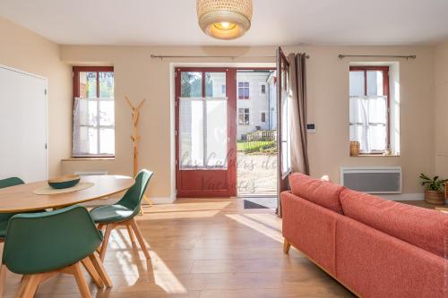 a living room with a red couch and a table at Les Cahiers de Vacances in Amboise