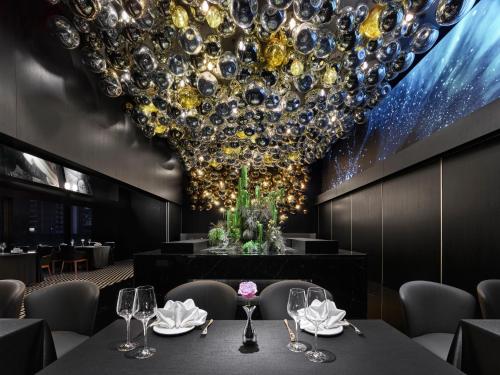 a dining room with a large chandelier at Maison Albar Hotels Leshan in Leshan