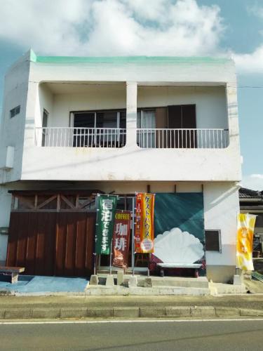 Ein weißes Apartmenthaus mit in der Unterkunft ゲストハウスジェイズ in Amagi