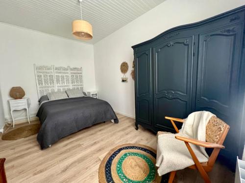 um quarto com uma cama e um armário azul em « La Souillarde » em Saint-Médard-en-Jalles